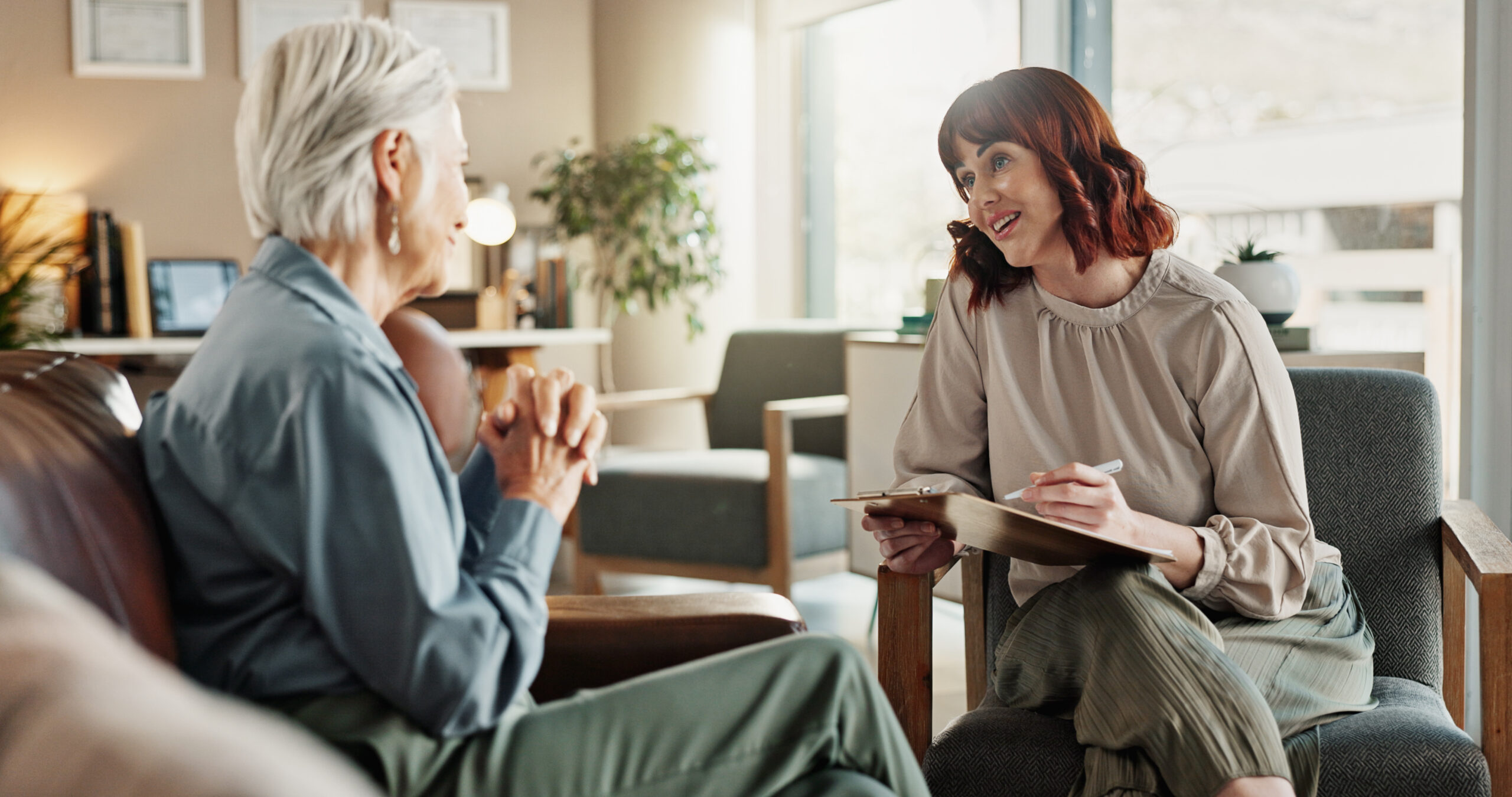 A clinician and a patient talking in a bright, comfortable consultation room